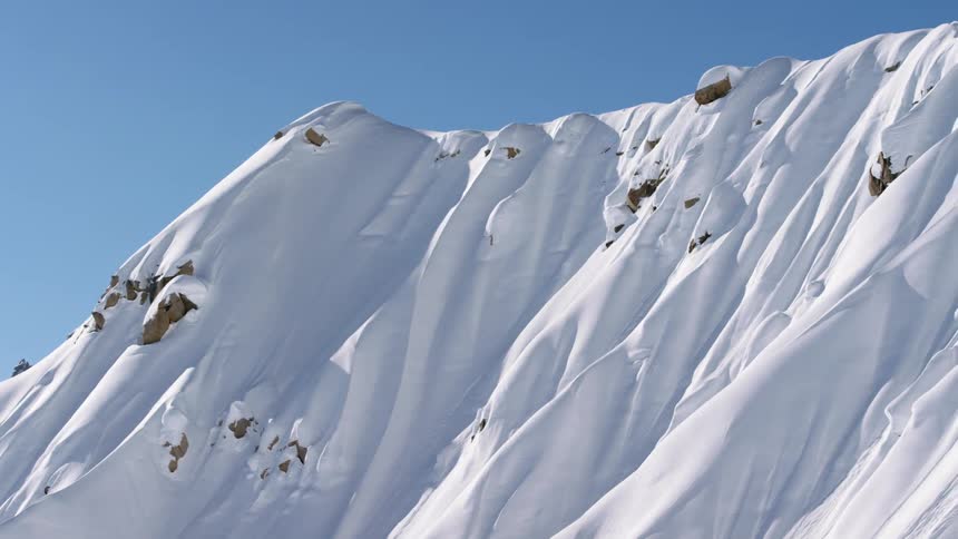 Parts of a mountain peak out from under a heavy blanket of snow