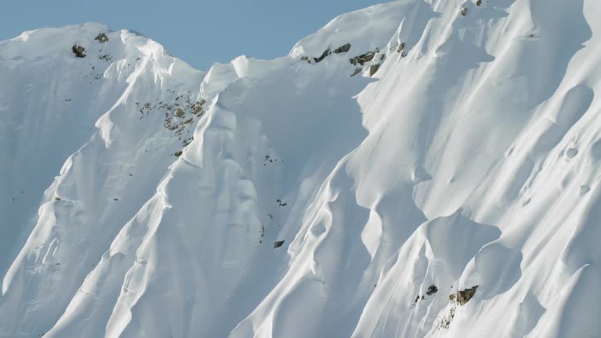 A snow covered mountain peak under a clear blue sky