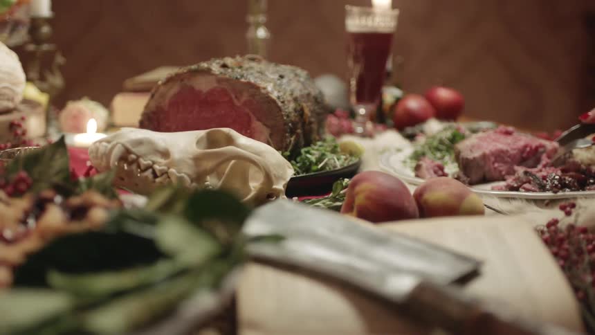 Woman cutting roast at fully laden feast table