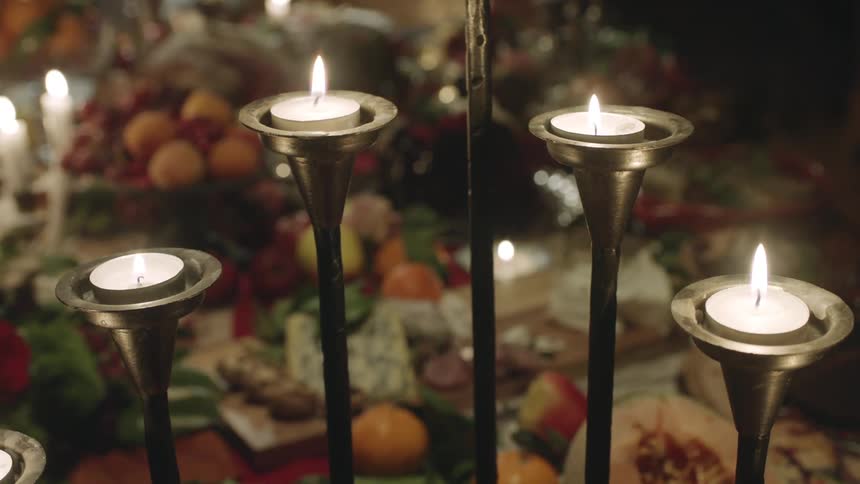 Candles burning with fruit in the background