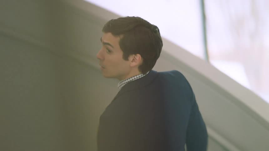 A young white male climbs a staircase in an office building