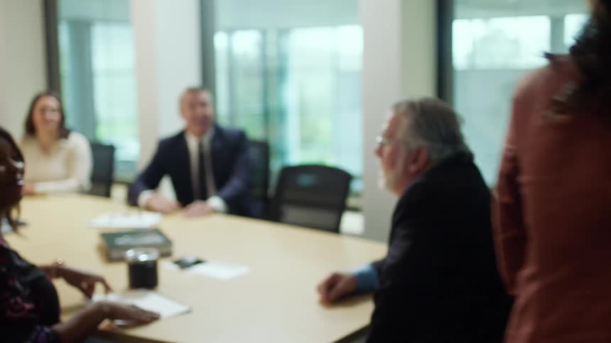 Woman prepares herself before entering conference room and shaking hands with colleague