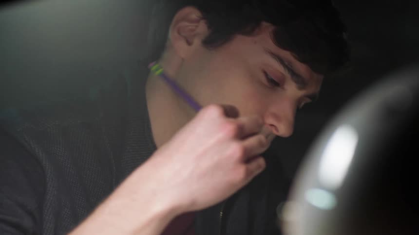 A teenage boy flips his pencil around as he thinks