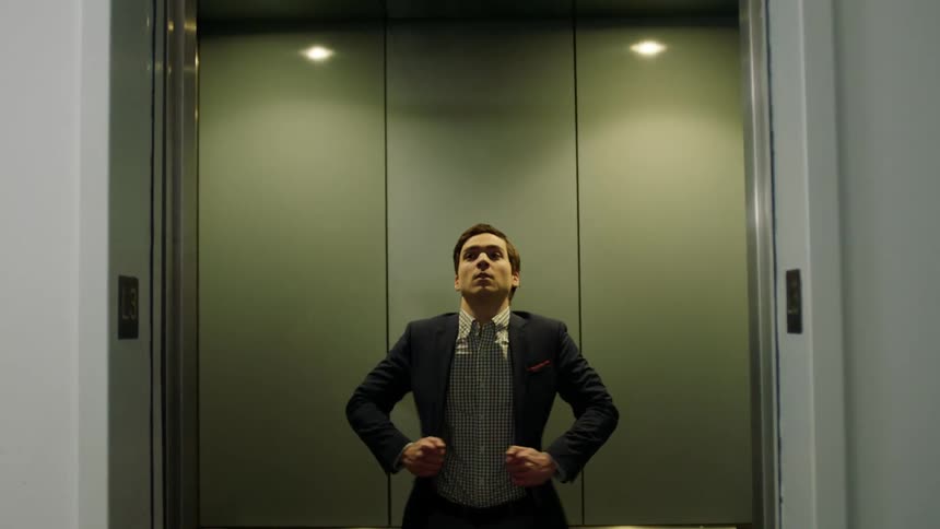 Young man in dress shirt and blazer enters elevator