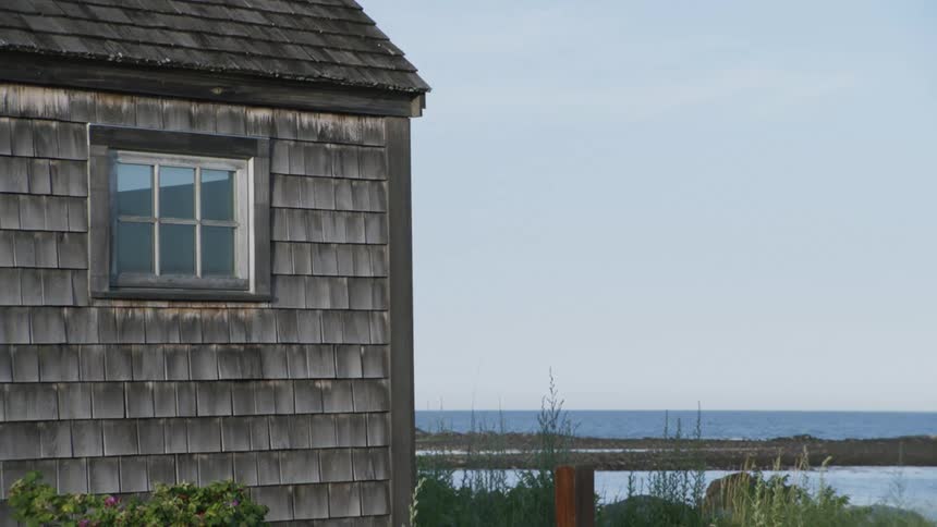 A house near the coast with the sky and the ocean in the background