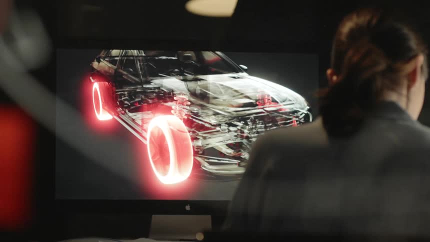 A white woman works on a car design in her office
