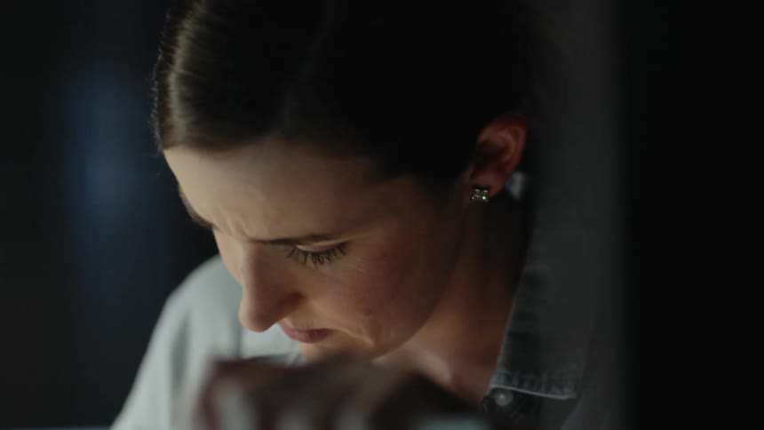 A woman in her office looks at her laptop with a worried expression