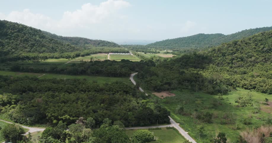 Aerial view of road traveling through tropical valley