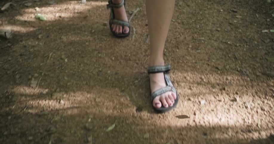 A woman wearing sandals is walking outdoors