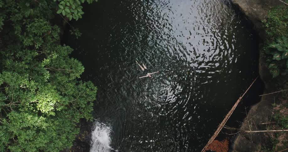 Woman floating in tropical swimming hole