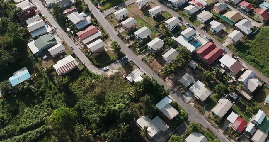 Cars drive down the road through an island neighborhood