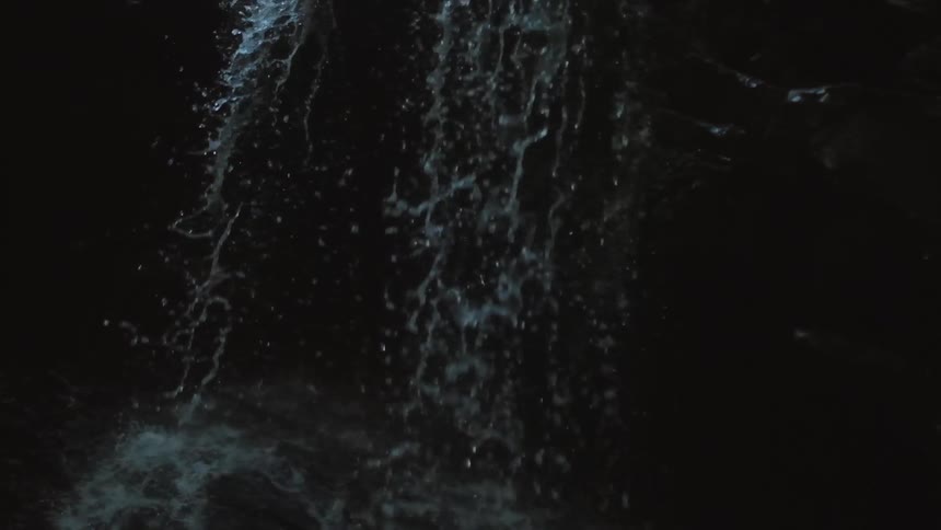 Small waterfall falling into pool of water in rainforest