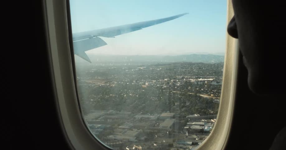 Woman looks out the plane window during the flight