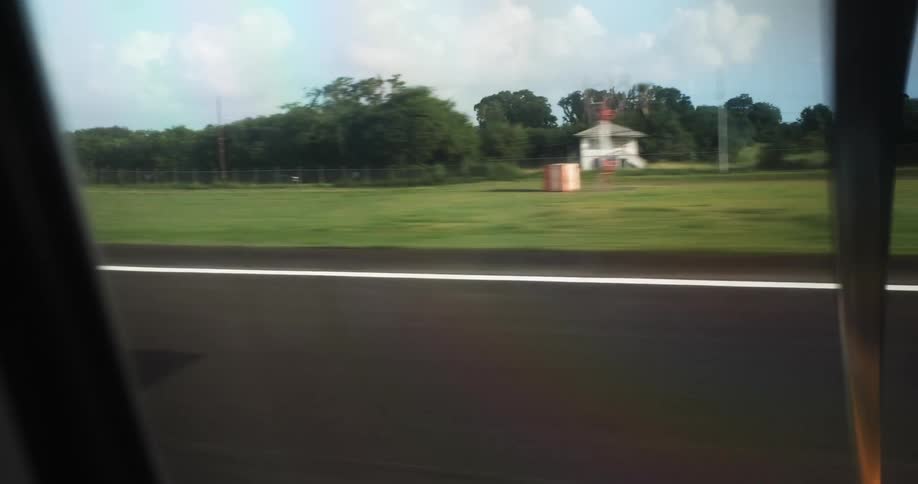 An airplane window as it drives on a runway