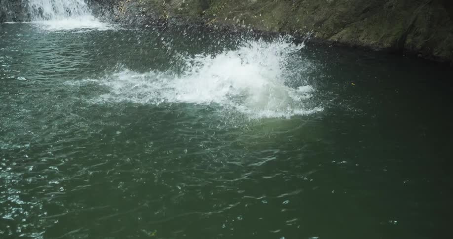Woman cliff diving into a watering hole