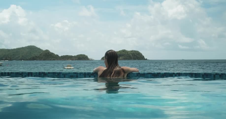 Woman enjoying a pool on the beach in the summer