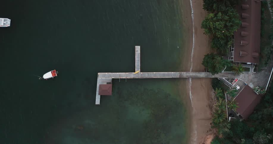 A house near the beach with a pier and boats