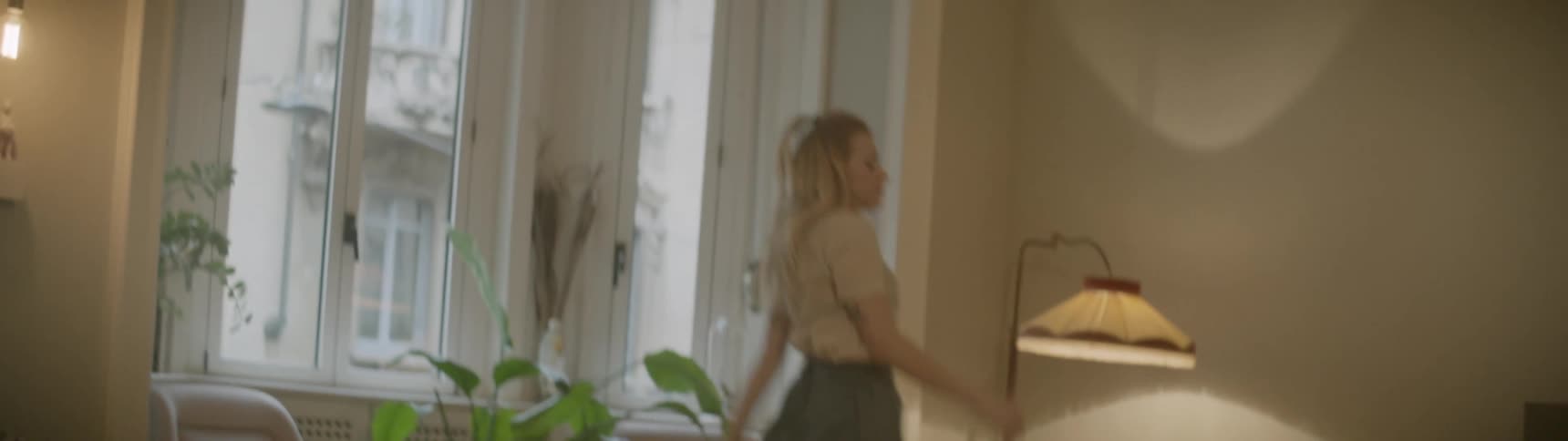 A woman in a room skipping around and dancing