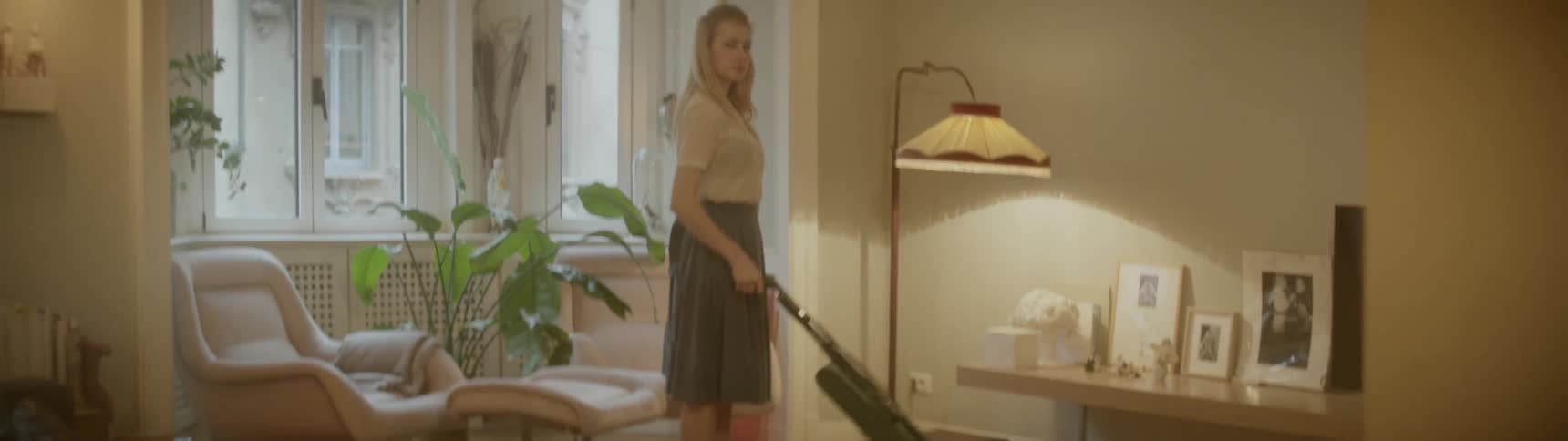 A woman uses an electric steam mop on her wood floor