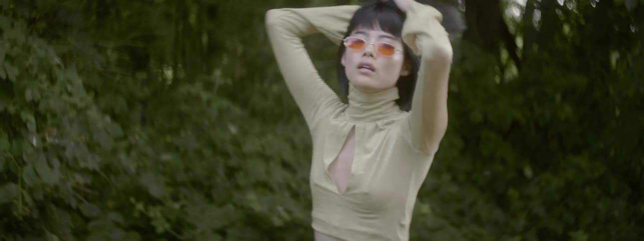 A woman with sunglasses posing and spinning