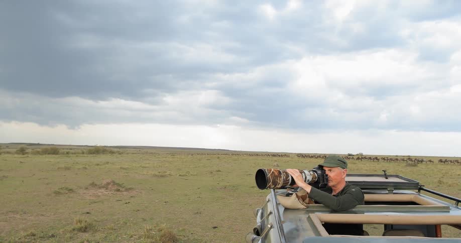 A photographer uses a large lens on a safari