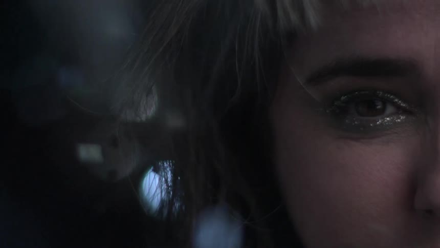 Glitter flies through the air around a white womans face