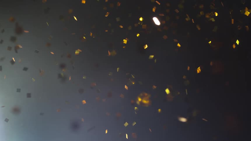 Confetti flies through the air and flares due to a light source