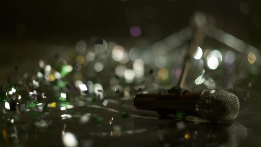 Glitter flies around as a microphone stand falls over and bounces on the floor