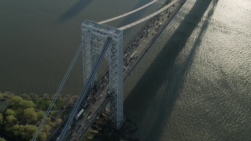Cars and trucks drive across a bridge suspended over water