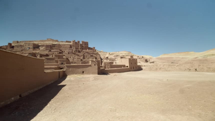 A man is photographing a rural town in the desert