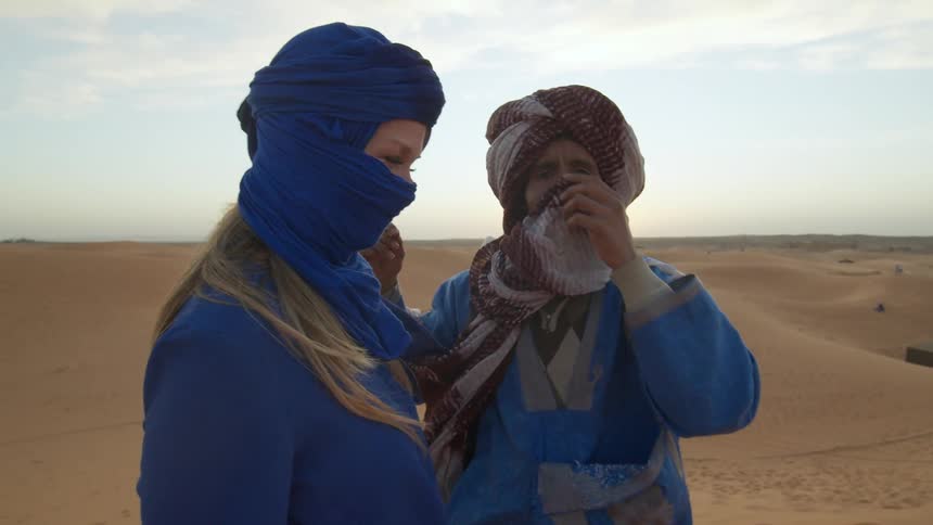 Two women are standing in a desert area