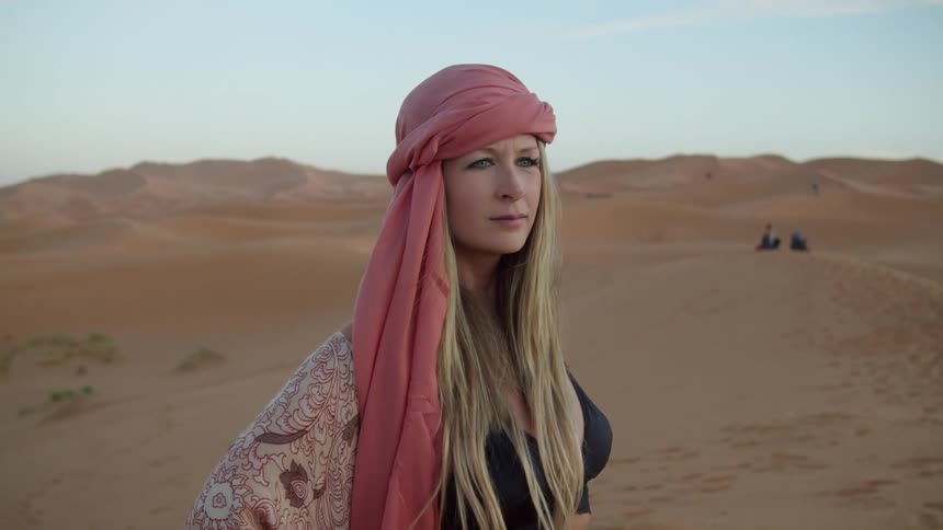 A woman is standing in a desert area