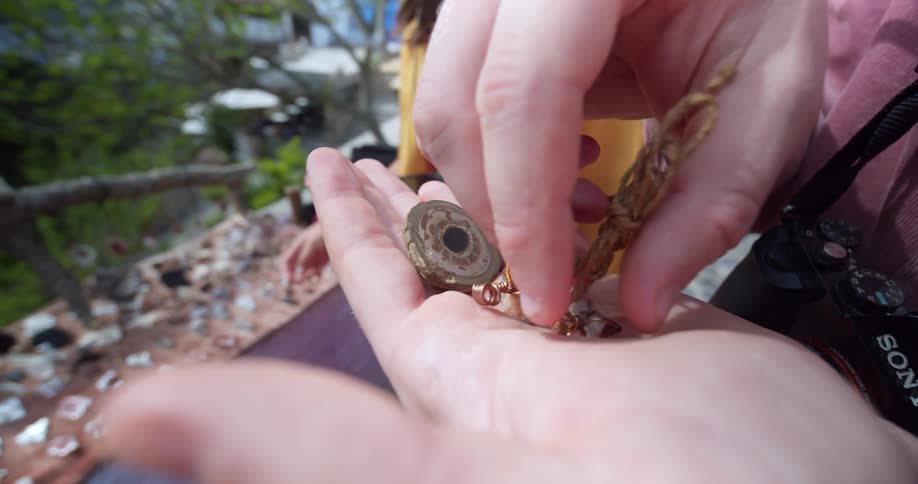 Two people browse outdoor jewelry stall