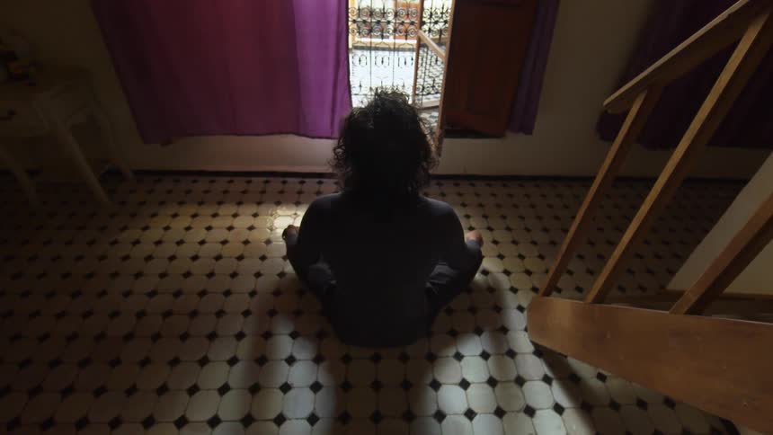 A person is sitting in the dark by the window