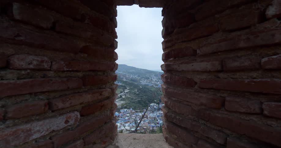 Houses in a neighborhood seen through a brick doorway