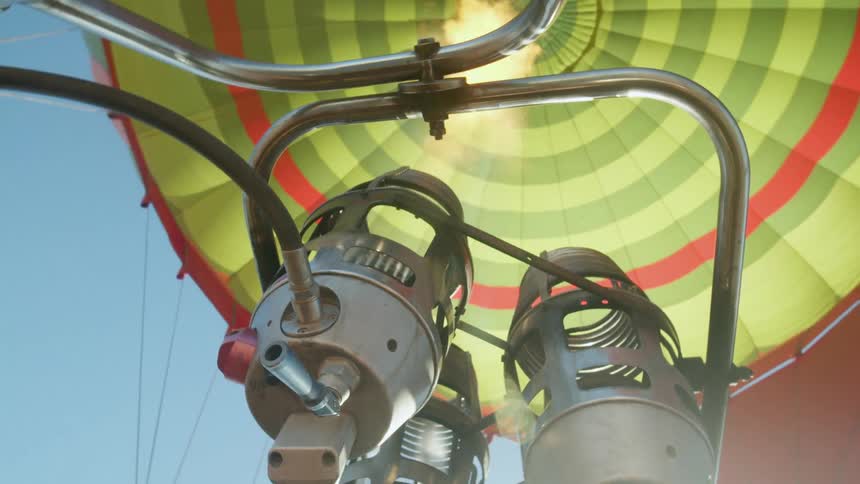 A pilot heats up the air in a hot air balloon with gas tanks