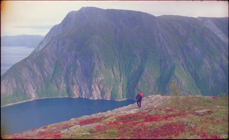 A man hiking past a lake