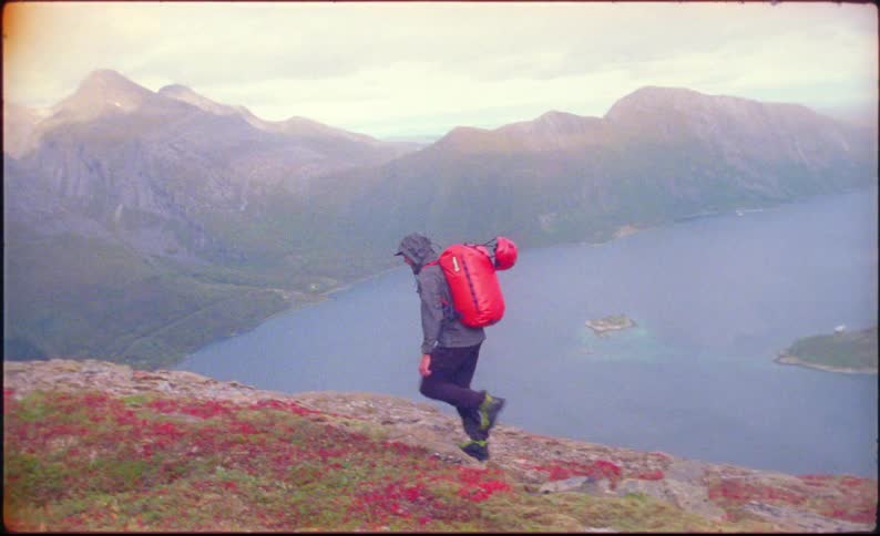 A man climbs up the mountain on a cloudy day