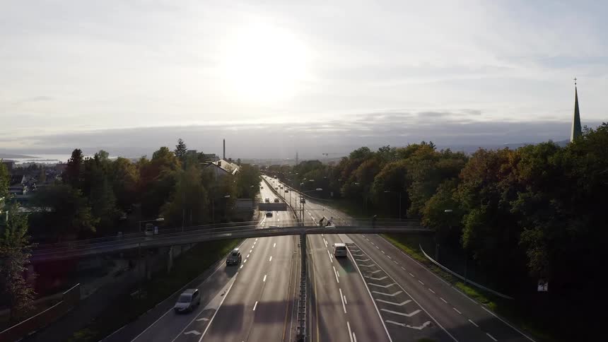 People ride skateboards on the overpass over the busy highway