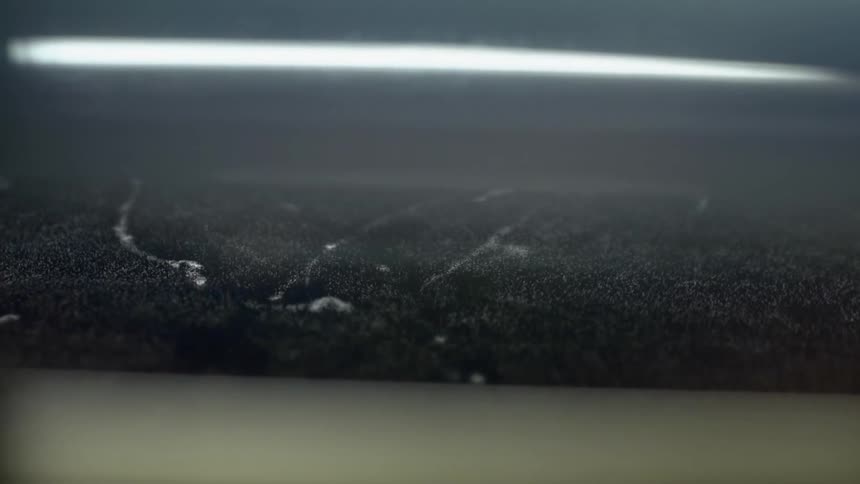 Clear spots and lines among black fuzz disappear as surface moves