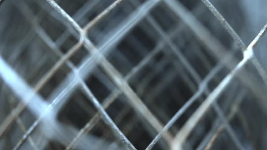 A chain link fence is rolled up in a barrel shape