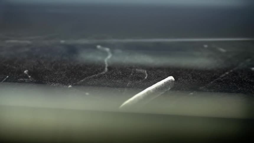 Fuzzy black surface flows and rolls under clear cover