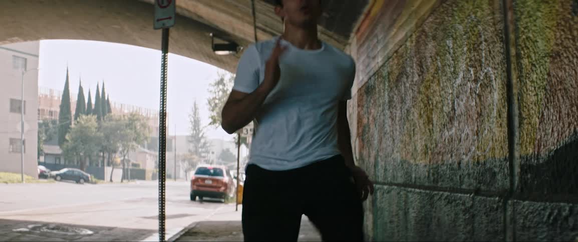 A man jogs quickly from one end of a tunnel to the other