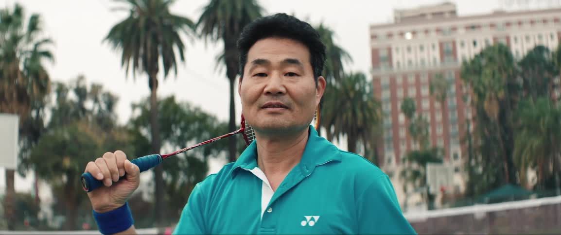 Man standing with badminton racket on shoulder