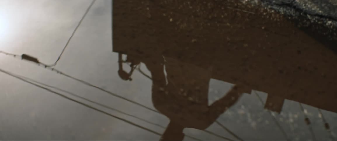 Reflection of person in puddle on asphalt