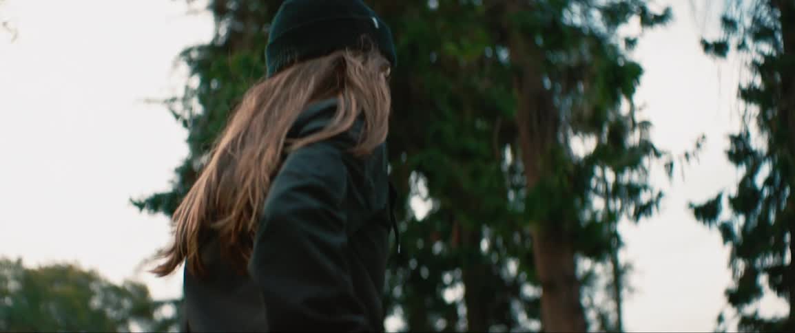 Young woman rides skateboard in the park