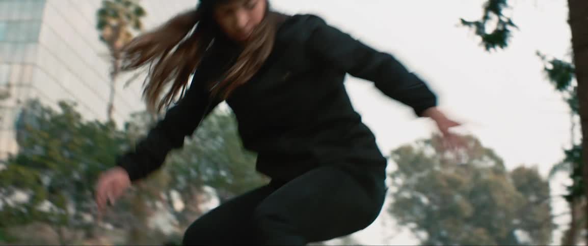 A skateboarder jumps off a ledge in a park
