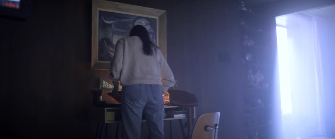 A woman sitting at her desk suddenly stands up and grabs her bag and books when leaving