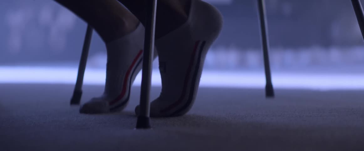 A persons feet with socks on tiptoeing while sitting on a chair