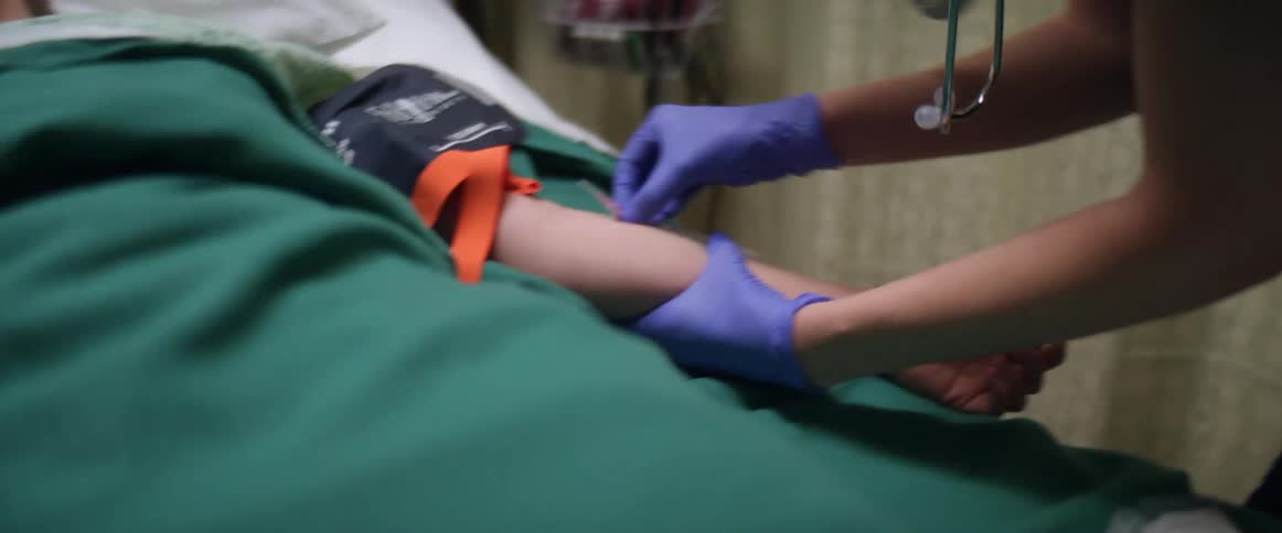 A nurse gives a hospital patient an injection in the arm